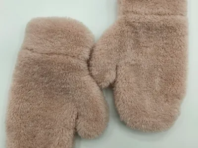 Ein Paar rosa flauschige Kunstfell-Winterfäustlinge, flach auf weißem Hintergrund liegend