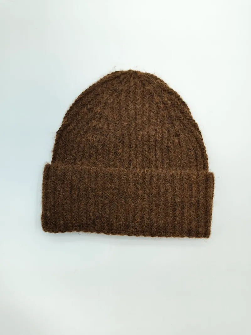 Braune grobgestrickte Winter-Beanie mit Umschlagbündchen, flach auf weißem Untergrund liegend