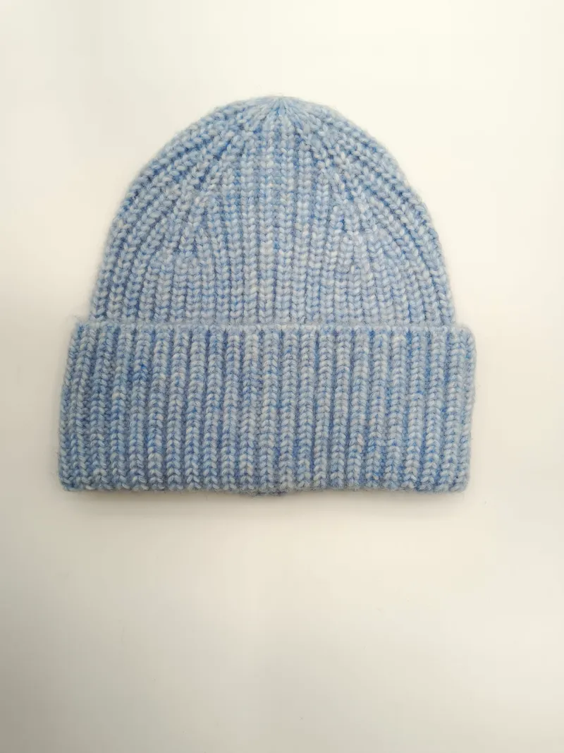 Pastellblaue Strickmütze mit strukturiertem Marl-Garn und umgeklapptem Rand, von oben fotografiert auf weißem Hintergrund