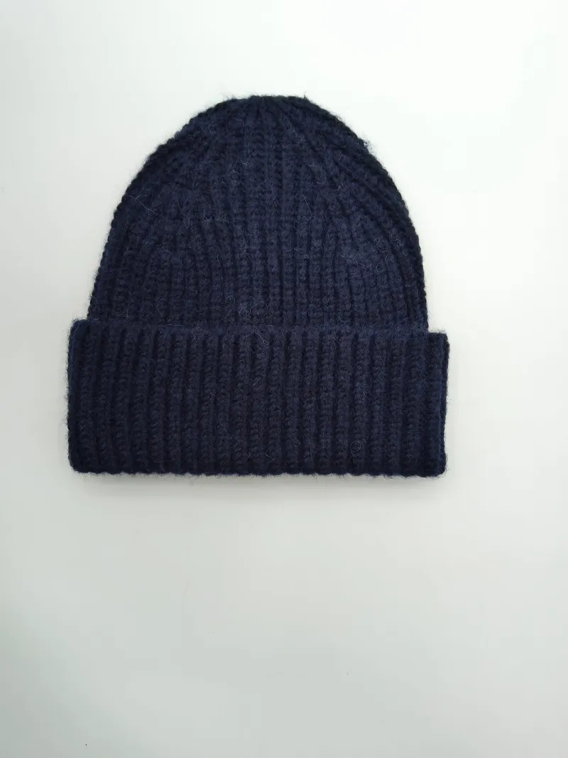 Marineblaue Strickmütze mit breitem Krempenumschlag aus grobem Rippenstrick, Draufsicht auf weißem Hintergrund