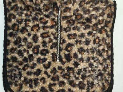 Gemusterter Sherpa-Fleece-Halswärmer im Leo-Design mit silbernem Halbzip und schwarzen Abschlusskanten, Flachbild auf weißem Hintergrund
