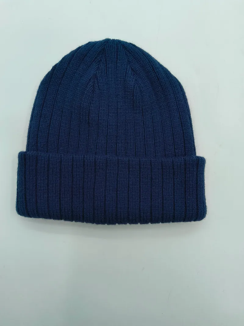 Marineblaue Wintermütze mit Rippenmuster und umgeschlagenem Rand, weicher Strickstoff, Draufsicht auf weißem Hintergrund