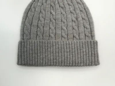 Hellgraue Zopfstrick-Wintermütze mit strukturiertem Flechtmuster und doppelt umgeschlagenem Bündchen, Flachbild auf weißem Untergrund