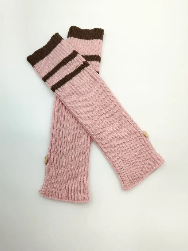 Fingerlose Armstulpen in altrosa Rippenstrick mit kontrastfarbenen braunen Streifen am Bündchen und kleinen dekorativen Knöpfen, Produktfoto auf weißem Hintergrund