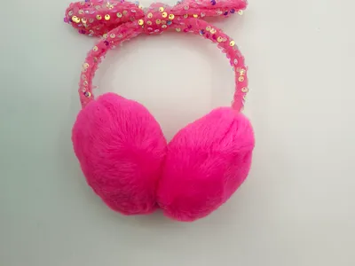 Leuchtend pinke Plüsch-Ohrenschützer mit glitzerndem pinkfarbenem Pailletten-Schleifenhaarreif, Kinderwinterzubehör auf weißem Hintergrund