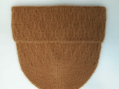 Karamellbraune flauschige Wintermütze mit Rippenstrick-Textur und doppelt umgeschlagenem Rand, Flachbild auf weißem Hintergrund
