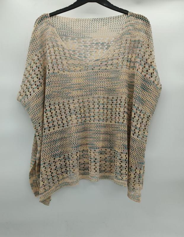 Beige-türkisfarbenes Häkelponcho mit Fledermausärmeln, Streifenmuster und großen Maschen auf einem Kleiderbügel in Studioaufnahme