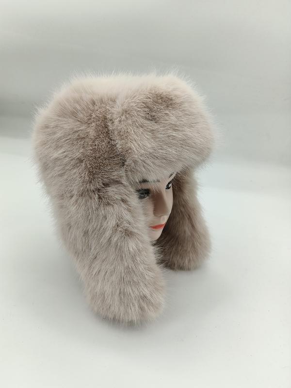 Flauschige Kunstpelzmütze in Beige im Ushanka-Stil mit langen Ohrklappen auf einem Modellkopf, seitliche Ansicht
