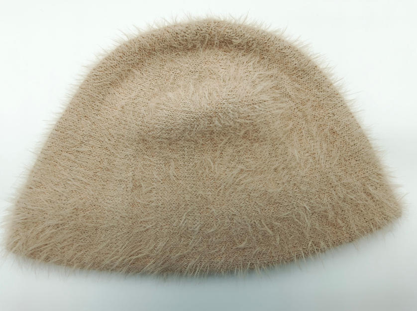 Beiger Fischerhut aus flauschigem Wimpernstrickstoff mit weicher, pelziger Oberfläche auf weißem Hintergrund