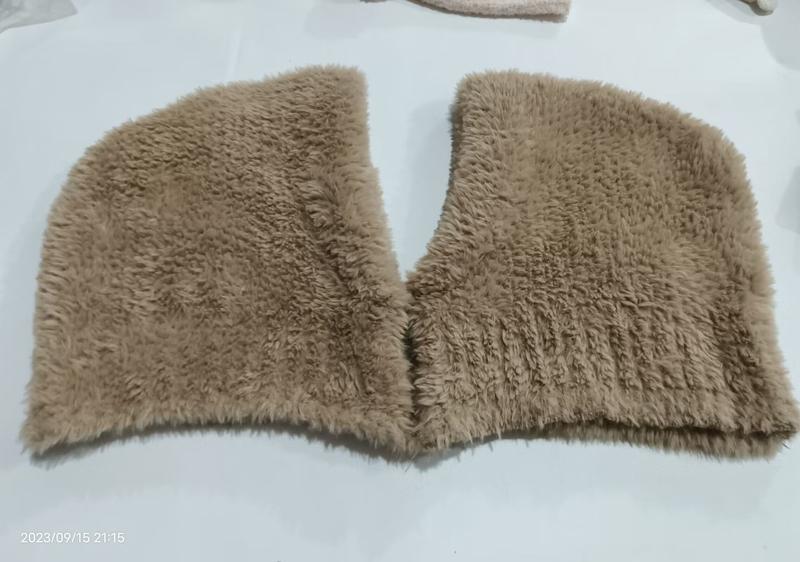 Beiger Kunstfell-Kragenschal in V-Form flach auf weißer Fläche liegend, fluffige Langhaarstruktur sichtbar