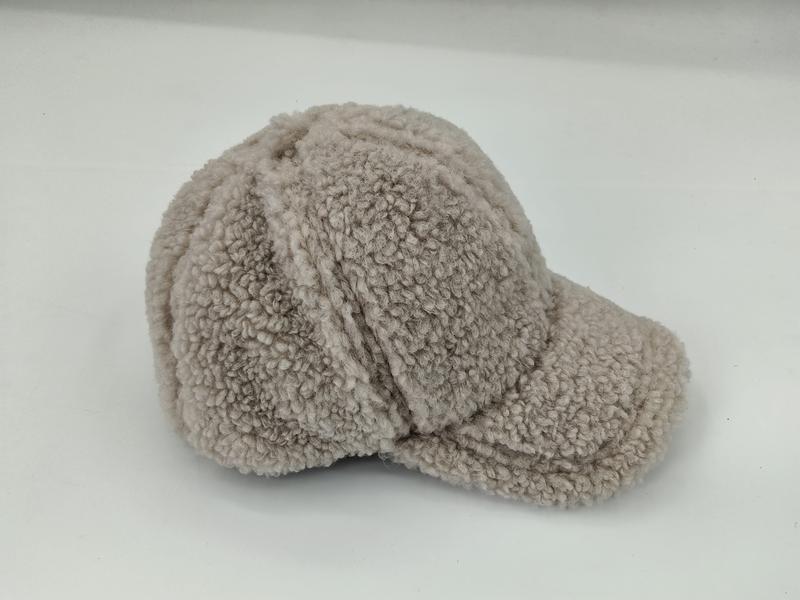 Strukturiertes Baseballcap aus flauschigem Beige-Teddystoff mit Nähten der 6-Panel-Konstruktion und festem Schirm, auf neutralem Hintergrund