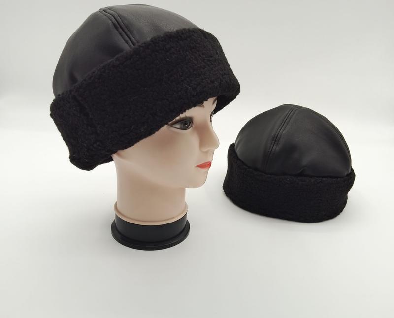 Schwarze Kunstleder-Beanie mit dicker Sherpa-Fleece-Krempe, auf Mannequin-Kopf und separat auf weißem Hintergrund präsentiert