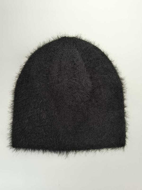 Schwarze Strickmütze mit flauschigen Mohair-artigen Fasern und gerippter Struktur, flach auf weißem Hintergrund liegend