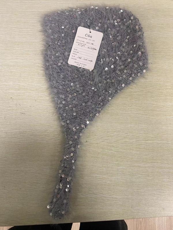 Schwarze Ohrenwärmer mit flauschigen Ohrmuscheln und gestricktem Bügel mit weißer Aufschrift und rotem Streifenmuster, weißer Hintergrund