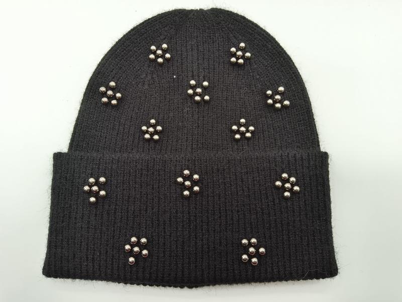 Schwarze Strick-Beanie mit Metallkugelnieten in floralen Cluster-Anordnungen auf Krempe und Kappe
