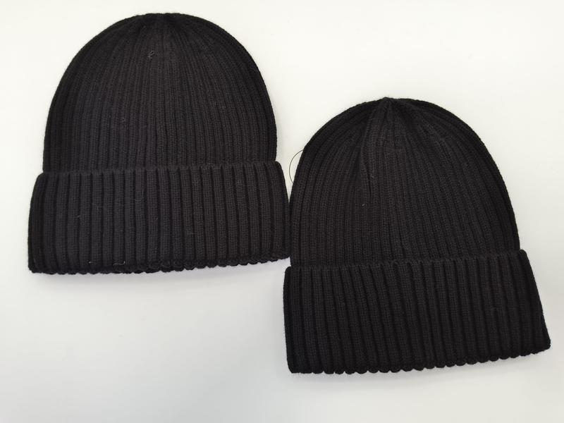 Zwei schwarze Rippstrick-Beanies mit Umschlagrand in verschiedenen Größen auf weißem Untergrund