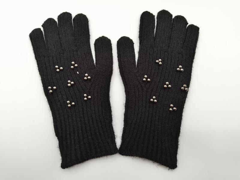 Paar schwarze gestrickte Winterhandschuhe mit silbernen Metallniet-Verzierungen auf dem Handrücken