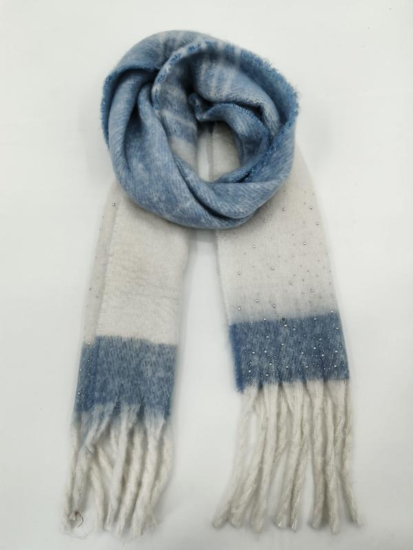 Weicher Winterschal in Blau-Creme-Karomuster mit aufgenähten Zierperlen und Fransenenden, spiralförmig auf hellem Hintergrund drapiert