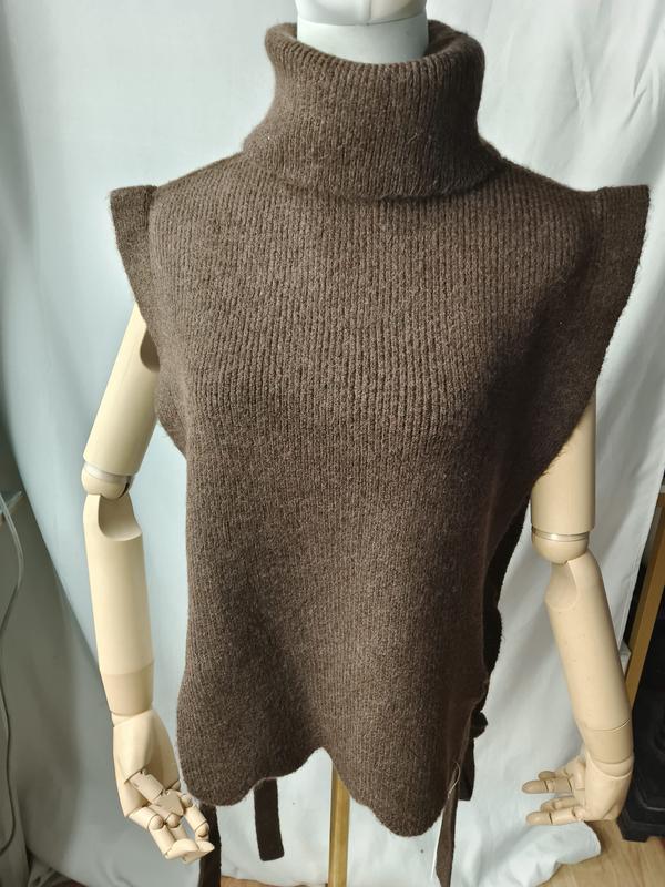 Braune grobgestrickte ärmellose Rollkragen-Weste mit Bogensaum und seitlichem Bindegürtel auf einer Schaufensterpuppe