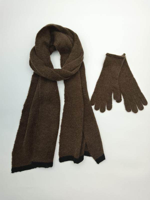Braunes Strick-Schal und passendes Handschuh-Set mit schwarzem Kontrastrand auf weißem Hintergrund
