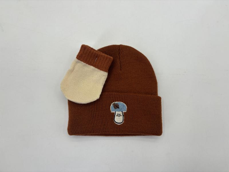 Braune Rippstrick-Wintermütze mit gesticktem Aufnäher, kombiniert mit cremefarbenem und braunem zweifarbigen Strickfäustling