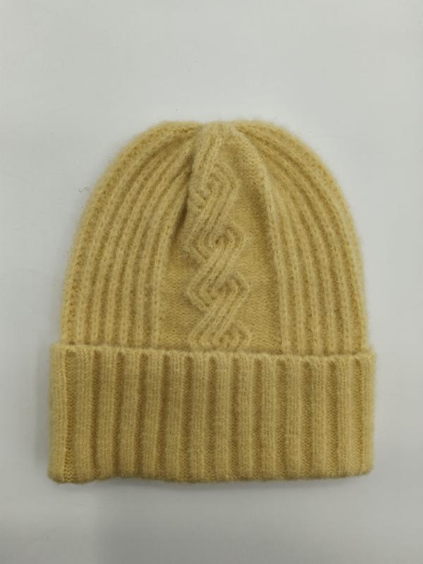 Buttergelbe gerippte Wollstrickmütze mit geometrischem Zopfmustermotiv und breitem Umschlagbündchen, flach auf weißem Hintergrund liegend