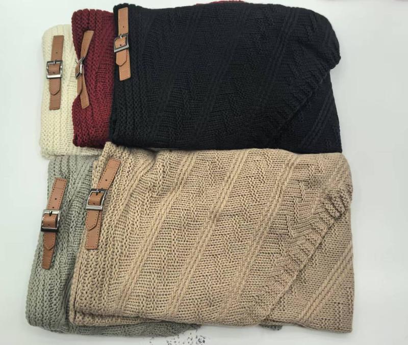 Fünf gefaltete Kuscheldecken aus Grobstrick in Beige, Grau, Schwarz, Burgund und Creme mit braunen Leder-Schnallenriemen