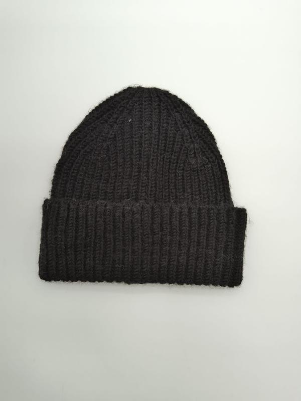 Schwarze Strickmütze mit grobem Rippenmuster und breitem Krempenumschlag, Draufsicht auf weißem Untergrund, warme Wintermütze
