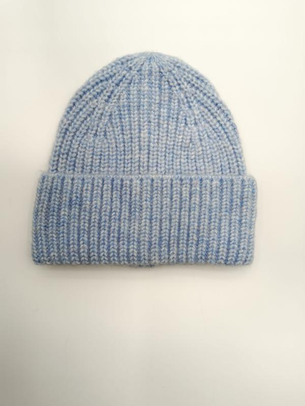 Pastellblaue Strickmütze mit strukturiertem Marl-Garn und umgeklapptem Rand, von oben fotografiert auf weißem Hintergrund