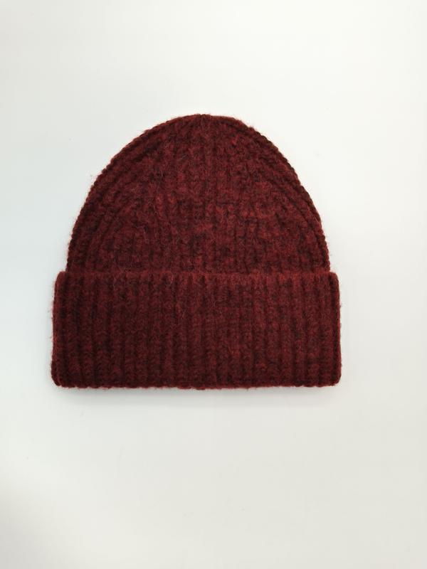 Dunkelrote grobgestrickte Rippstrick-Beanie mit umgeschlagenem Bündchen, flach auf weißem Hintergrund