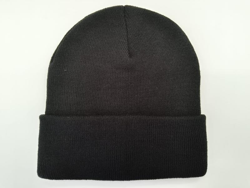 Schlichte schwarze Rippenstrick-Mütze mit gefaltetem Umschlag, flach auf weißem Hintergrund, unisex