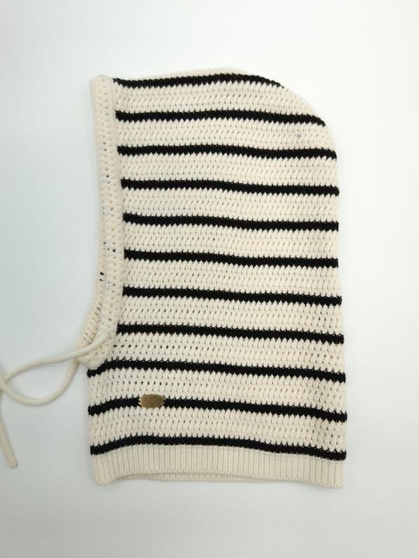 Creme-schwarz gestreifte Häkel-Balaclava flach liegend mit Ripprand, Schnürverschluss und kleinem goldenem Markenlabel