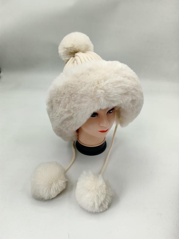 Weißer Kunstfell-Winterhut mit gestricktem Bommel an der Spitze und herabhängenden Pelz-Pompom-Bindebändern auf einer Hutform