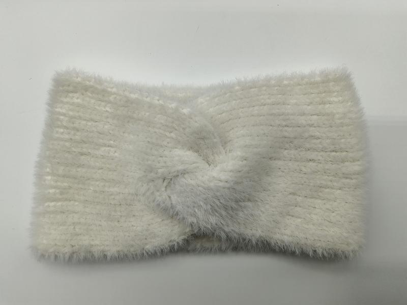Weiches cremefarbenes Haarband aus flauschigem Rippstrick mit dekorativem Twist-Knoten in der Mitte, auf hellem Untergrund