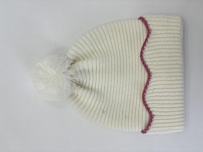 Cremefarben grob gestrickte Wintermütze mit fluffigem Bommel oben und dekorativer rosa Zickzack-Stickerei am Rand