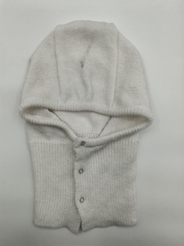 Cremeweiße gestrickte Baby-Helmhaube mit umklappbarer Kapuze und silbernen Druckknöpfen, flach auf weißem Untergrund fotografiert