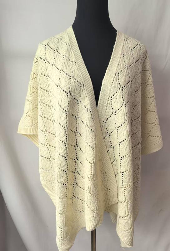 Elfenbeinfarbener Strickponcho mit offenem Rautenmuster und Blatt-Stichdetails auf schwarzer Schneiderpuppe