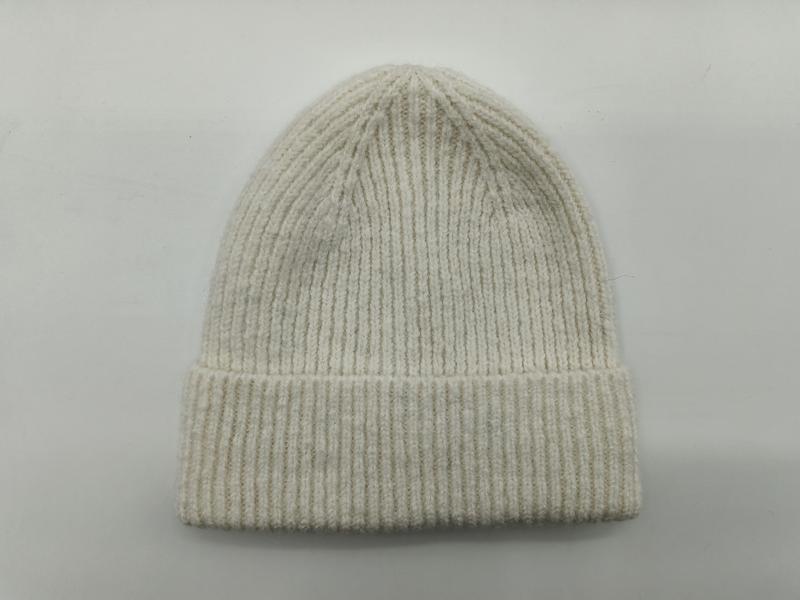 Hellbeige Rippenstrick-Wintermütze mit breitem Umschlagbund, flach auf grauem Hintergrund drapiert