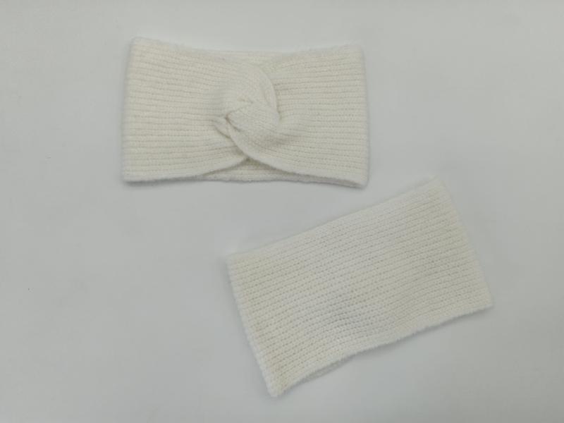 Creme geripptes Strick-Stirnband mit Twist-Knoten und passender Pulswärmer, flach auf weißer Oberfläche ausgelegt
