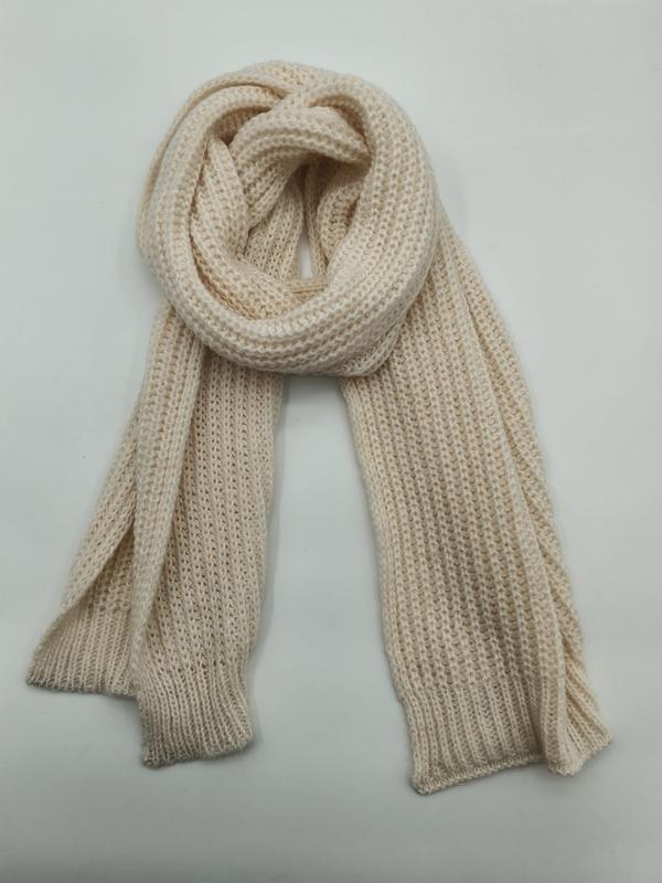 Cremefarbener Strickschal mit strukturierter Waffeloptik, locker aufgerollt und flach drapiert, Detailaufnahme der Textur