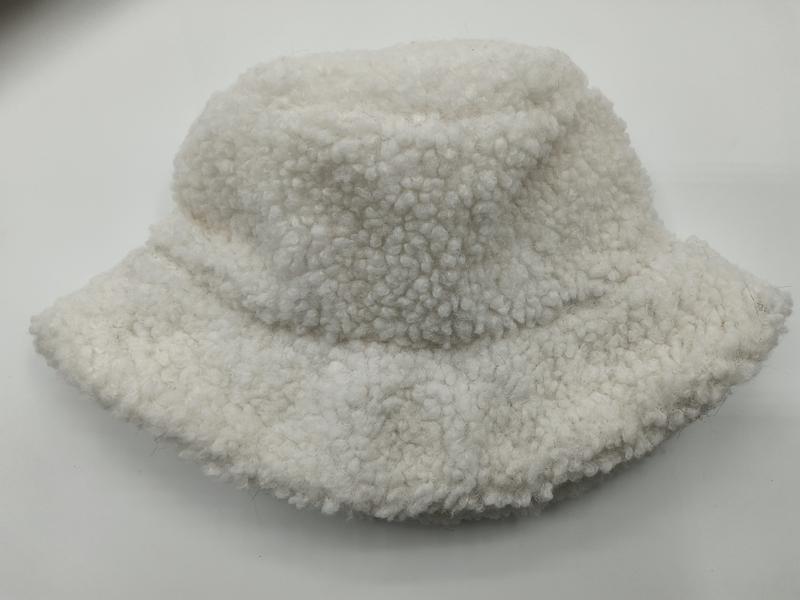 Cremeweiße Sherpa-Fischermütze mit fluffiger Boucle-Textur auf weißem Hintergrund, weiches Winter-Accessoire