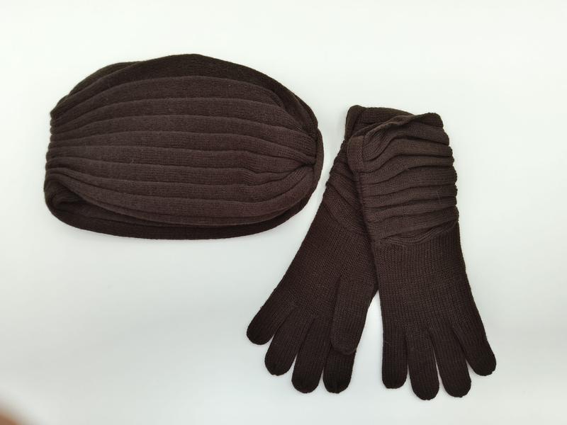 Dunkelbraune Rippenstrick-Wintermütze mit langen passenden Strickhandschuhen als Set auf weißem Hintergrund