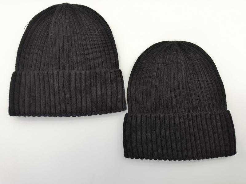 Zwei Rippenstrick-Beanies nebeneinander, einer in Dunkelgrau und einer in Schwarz, beide mit gefaltetem Umschlag auf weißem Hintergrund