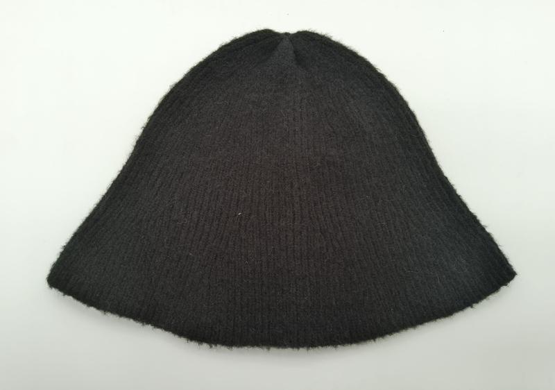 Dunkel anthrazitfarbene Rippenstrickmütze aus Wollmisch flach liegend, mit sichtbarer Rippenstruktur auf weißem Hintergrund
