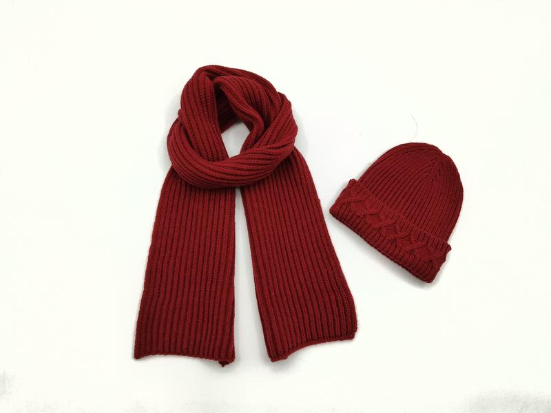 Dunkelroter Rippenstrick-Schal neben passender Zopfmuster-Beanie-Mütze auf weißem Hintergrund
