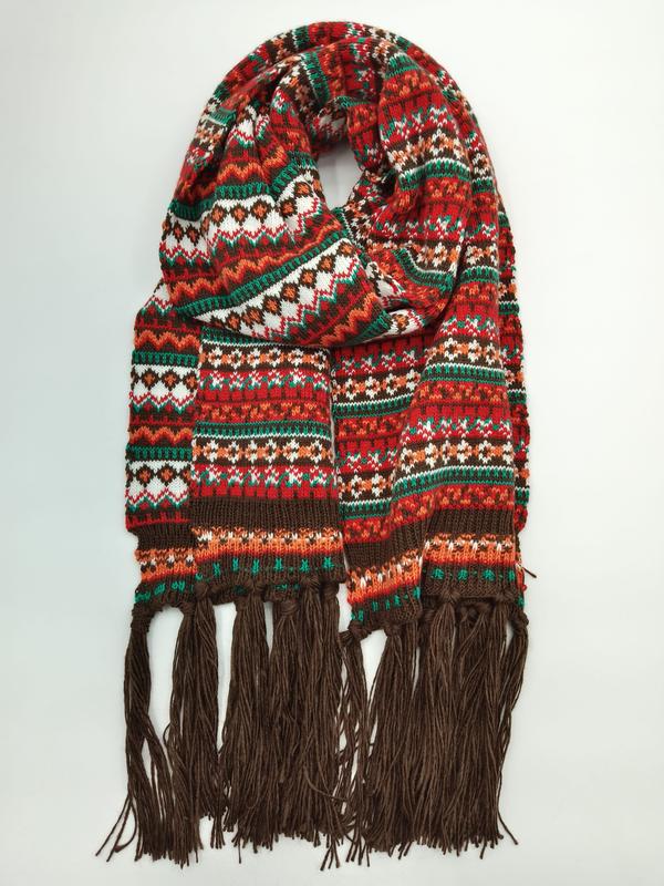 Aufgerollter Fair-Isle Strickschal in Rot, Grün, Orange und Weiß mit geometrischen Mustern und langen braunen Fransenden