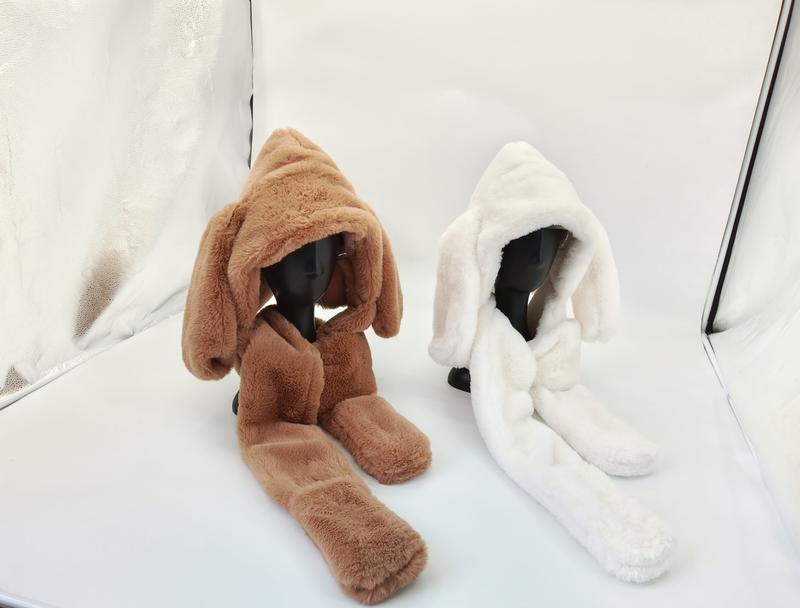 Zwei plüschige Kunstfell-Kapuzensets mit langen Tierohren in Braun und Weiß auf Schaufensterpuppenköpfen präsentiert