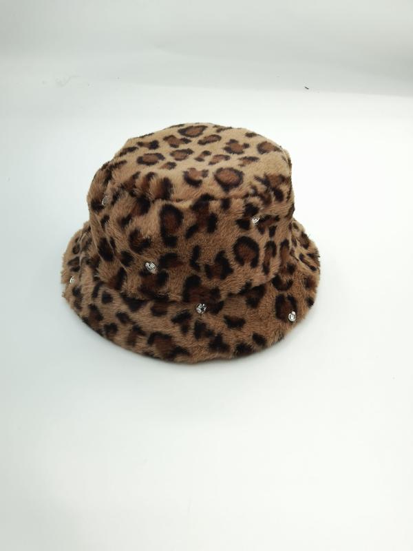 Flauschiger Bucket Hat im Leo-Print aus Kunstfell in Beige-Braun-Tönen mit funkelnden Kristallsteinchen als Dekoration, Produktfoto auf weißem Untergrund