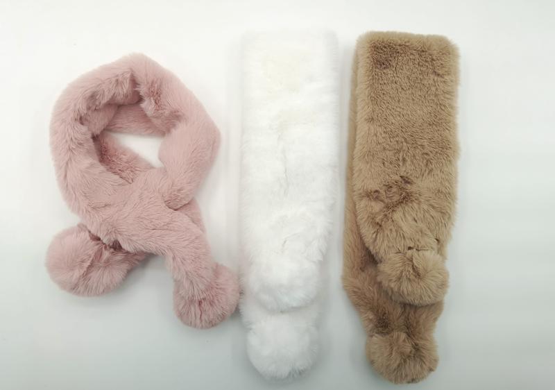 Drei flauschige Kunstfell-Schlauchschals mit Bommelenden in Blassrosa, Weiß und Sandbeige, als Flachaufnahme auf weißem Hintergrund