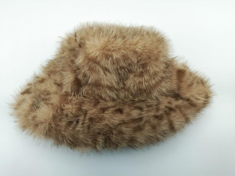 Beige-brauner Kunstfell-Bucket-Hat mit fleckigem Muster und flauschiger Textur auf weißem Hintergrund